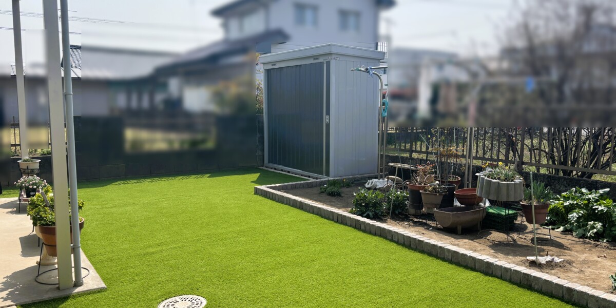 雑草対策にもなるメンテナンスフリーの人工芝敷きとレンガで囲んだ花壇の明るいお庭の施工例｜扶桑町